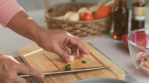 Female hand using a knife to cut Negi (Japanese Long Onion) or Japanese Scallion Stock Footage 242549410