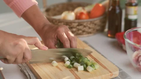 Female hand using a knife to cut Negi (Japanese Long Onion) or Japanese Scallion Stock Footage 242549779