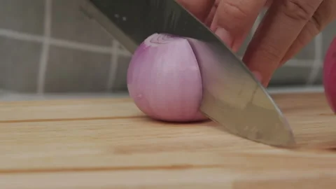 Female hand using knife to slice fresh red onion on chopping board, close-up. Stock Footage 243193192