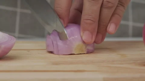 Female hand using knife to slice fresh red onion on chopping board, close-up. Stock Footage 243193219