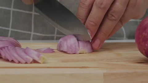 Female hand using knife to slice fresh red onion on chopping board, close-up. Stock Footage 243193361