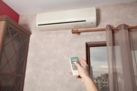 Female hand using remote controller for adjust Air conditioner. Foto stock