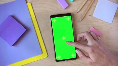 Female hand using smartphone with green screen on wooden background, top view Stock Footage 201452786