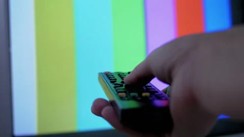Female Hand Using TV Remote Control Tries a Switch SMPTE Color Bars Test Pattern Stock Footage 149366343