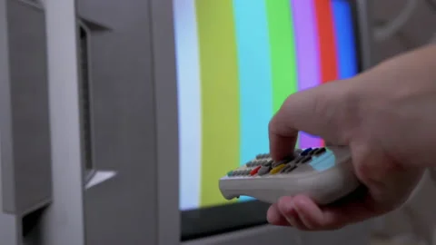 Female Hand Using TV Remote Control Tries a Switch SMPTE Color Bars Test Pattern Stock Footage 149369010