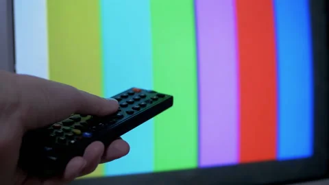 Female Hand Using TV Remote Control Tries a Switch SMPTE Color Bars Test Pattern Stock Footage 149370789