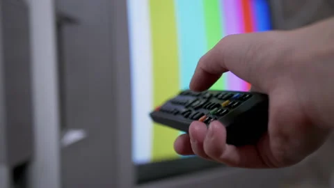 Female Hand Using TV Remote Control Tries a Switch SMPTE Color Bars Test Pattern Stock Footage 149375031