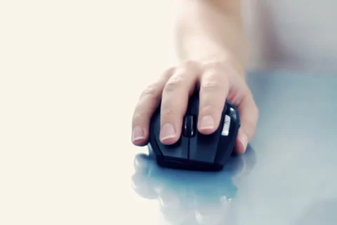 Female hand using a wireless computer mouse on reflective table Stock Footage