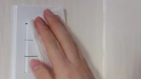 Female hand washes the switch with white napkin close-up Stock Footage 146197686