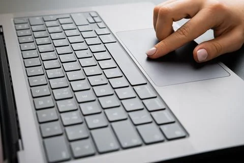 Female hand working on a computer touchpad. Business office workplace concept Stock Photos