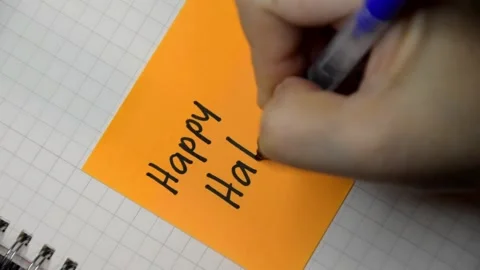 Female hand writes down a message with black pen on a sticky note. Stock Footage 346005988