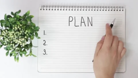 Female hand writes in notepad of plan on white background, top view Video stock 137549168