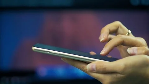 Female hand writing a message on a smart-phone on a laptop screen background. Stock Footage 81517606