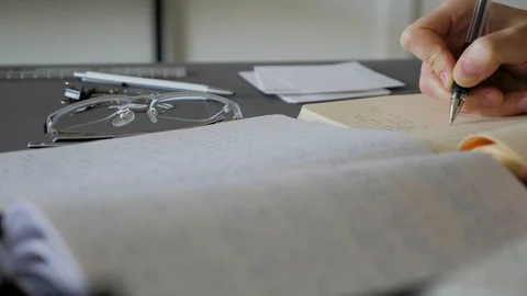 A female hand writing notes in notepad. Doing homework. Stock Footage 129500945