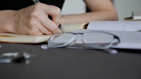 A female hand writing notes in notepad. Doing homework. Stock Footage 129812902
