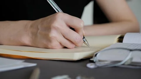 A female hand writing notes in notepad. Doing homework. Stock Footage 130667033