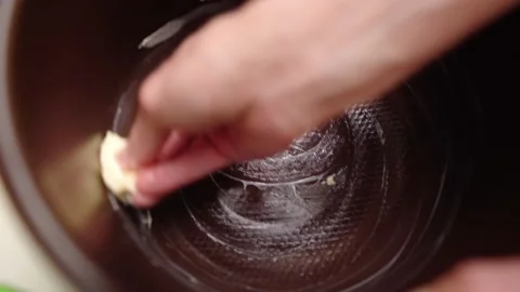 Female hands add or spread butter bottom multicooker bowl. Stock Footage 144390925