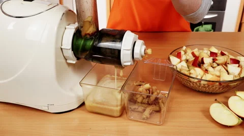 Female hands adding apple fruits in juicer machine 4K Stock Footage 61574859