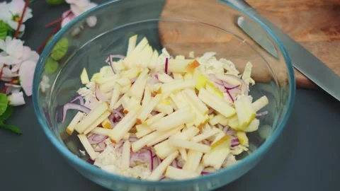 Female hands adding shredded apples to cabbage salad in kitchen Видео 342876863