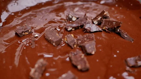 Female hands adding small pieces of chocolate into chocolate dough in bowl.  Stock Footage 158661139