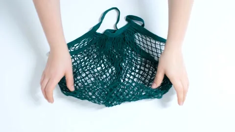 Female hands and green string bag on white background close-up. Stock Footage 168956016