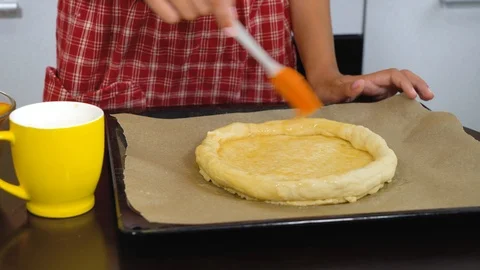 Female hands applying egg grease on raw dough Stock Footage 126370659