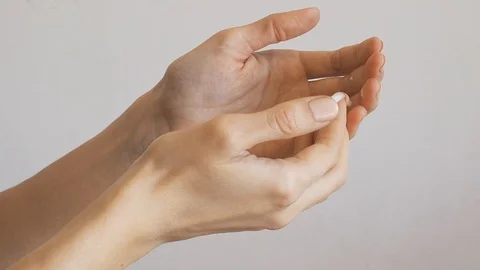 Female hands applying hand cream over gray wall Stock Footage 126873165