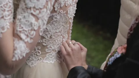 Female hands are buttoning the bride's dress. Stock Footage 68446441