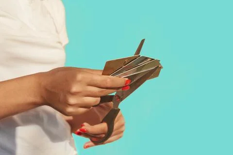 Female hands are cutting a stack of credit cards with scissors Stock Photos