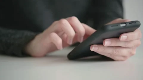Female hands are leafing through the pages in the smartphone display, side view. Stock Footage 153511440