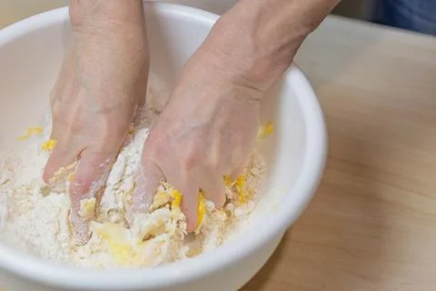 Female hands are processing dough for baking closeup. Stock Photos