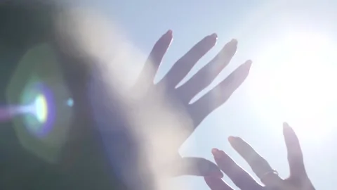 Female hands on a background of sky with the rays of the sun. Stock-Footage 140321002