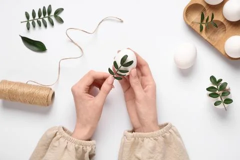 Female hands with beautiful Easter eggs, threads and green twigs isolated on  Stock Photos