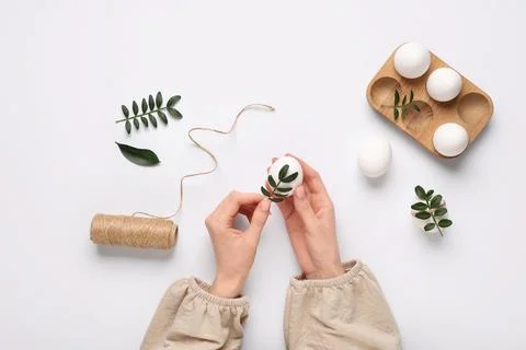 Female hands with beautiful Easter eggs, threads and green twigs isolated on  Stock Photos