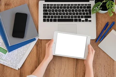 Female hands with blank tablet computer and laptop on table, top view Foto stock
