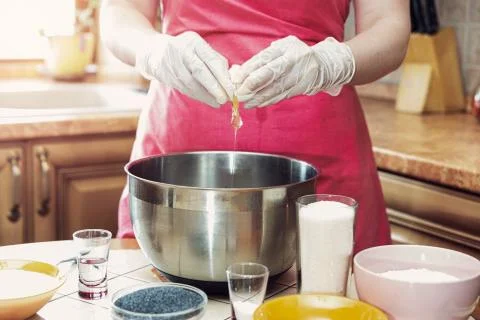 Female hands break an egg to make cake dough Stock Photos