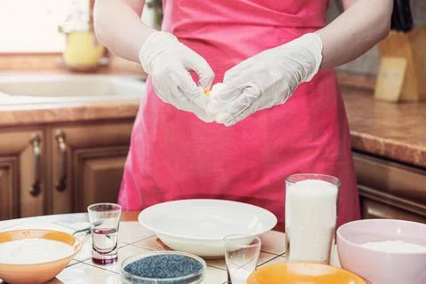 Female hands break an egg to make cake dough. Stock Photos