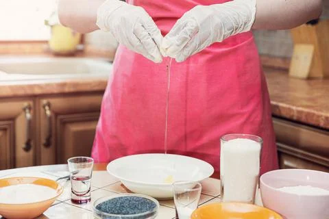 Female hands break an egg to make cake dough Stock Photos
