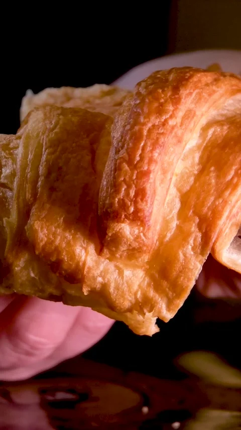 Female hands break a fresh warm croissant delicious breakfast homemade cakes on Stock Footage 248206987