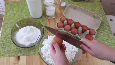 Female hands breaking a chicken egg with a knife Stock Footage 233430828