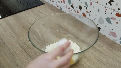 Female hands breaking an egg into a bowl with pot cheese. Stock Footage 266424029