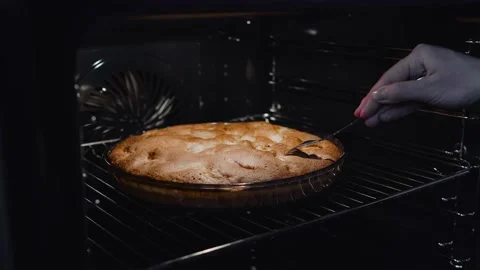Female hands checking if the cake is baked before removing it from the oven Stock-Footage 146908595