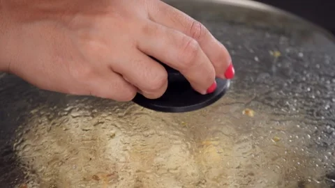Female hands checking out the freshly made popcorns in a frying pan at home Stock-Footage 156778016