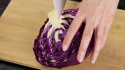 The female hands of the chef divide and cut the red cabbage Stock Footage 107577381
