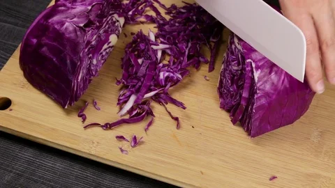 The female hands of the chef divide and cut the red cabbage for salad or stewing Stock Footage 107577545