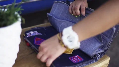 Female hands choosing cloth patch from denim pile variety Stock Footage 76538489