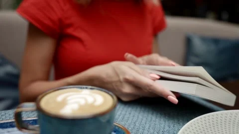 Female hands close the book and take a cup of coffee. close-up. small depth of Stockbeeldmateriaal 163659145
