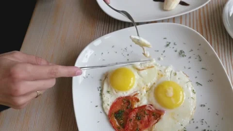Female hands close-up with fork and knife over scrambled eggs. woman having Stock-Footage 139704492