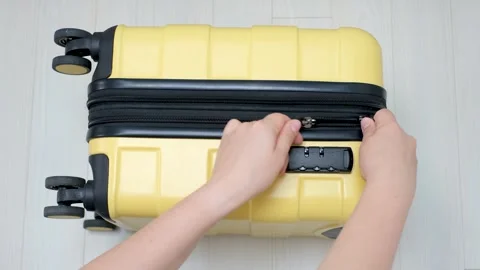 Female hands close the lock on a yellow suitcase close-up top view. Stock Footage 252797695