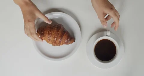 Female hands close up taking cup of black coffee with croissant for morning  Stock Footage 113729963